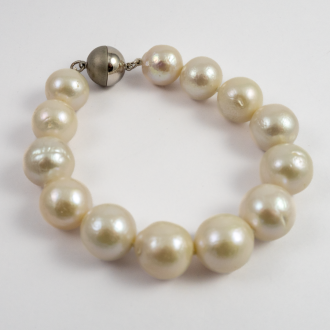 A BRACELET of White Round Freshwater Pearls on Silver Clasp. 12mm Diameter.