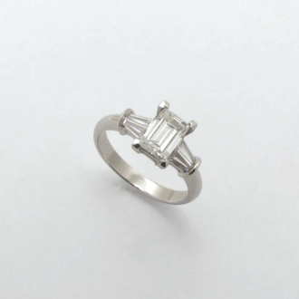 A Handmade Platinum and Diamond RING, with Family Heirloom Emerald-cut Diamond at centre and two tapered Baguettes on each shoulder.
