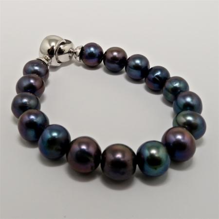 A BRACELET of Black Off-round Freshwater Pearls on Silver clasp.