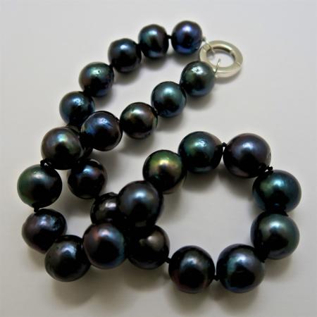 A NECKLACE of Off-Round Black Freshwater Pearls on Sterling Silver Clasp.