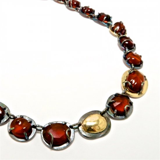 A Handmade Sterling Silver and 9ct Yellow Gold NECKLACE with Rose-cut and Carved Hessonite (131.64cts.). (Gold mass 5.1 gms.
