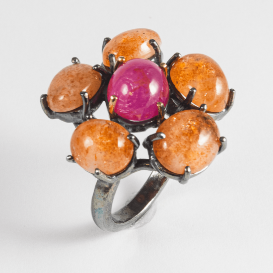 A Handmade Oxidised Sterling Silver, 18ct Yellow Gold, Cabochon Sunstone and Ruby (0.68ct) DAISY RING.  Gold mass 0.83 gms