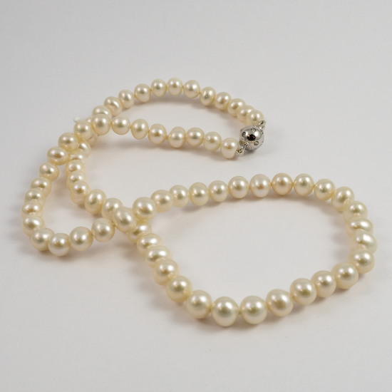 A NECKLACE of White Round Freshwater Pearls on Silver Clasp. 6mm Diameter.