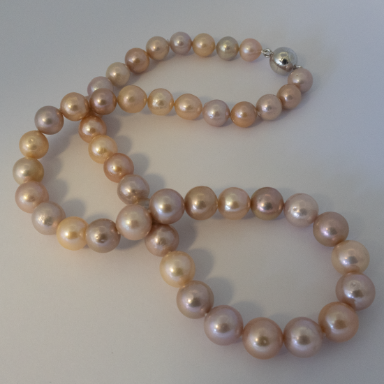A NECKLACE of Natural off-Round Freshwater Pearls on Silver Clasp. 9.5-10mm Diameter.