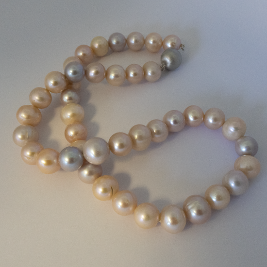 A NECKLACE of Natural off-Round Freshwater Pearls on Silver Clasp. 10.5-11mm Diameter.