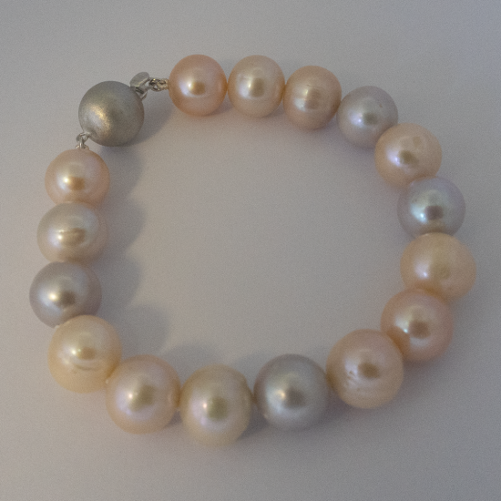 A BRACELET of Natural off-Round Freshwater Pearls on Silver Clasp. 10.5-11mm Diameter.